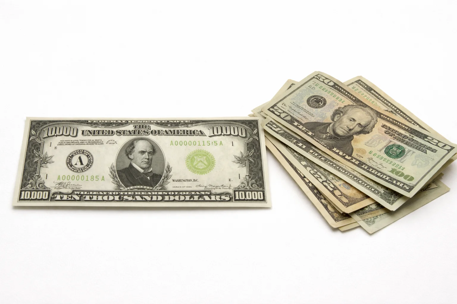 $10,000 bill next to smaller U.S. banknotes.